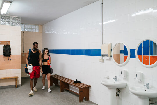 Diverse sportspeople entering dressing room - Powered by Adobe