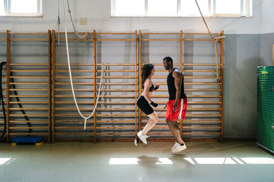 Happy diverse athletes jumping rope during workout