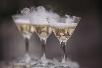 Wedding catering. Celebration marriage concept. Restaurant and bar alcohol menu. Luxury drink. Banquet service outdoor. Cocktails in pyramid setup decor. Waiter brings glasses of champagne. 