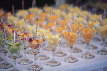 Catering on wedding. Wedding banquet table. Sweet table with fruit. Fruit bar on party. Delicious fruits appetizers, desserts on stand, modern sweet tab.