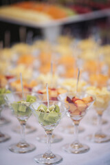 Catering on wedding. Wedding banquet table. Sweet table with fruit. Fruit bar on party. Delicious fruits appetizers, desserts on stand, modern sweet tab.