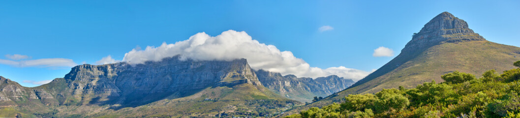 Fototapeta premium Panoramic landscape of Table Mountain and Lions Head in Cape Town, South Africa. Aerial view of a majestic and breathtaking blue sky background over a natural wilderness environment during summer