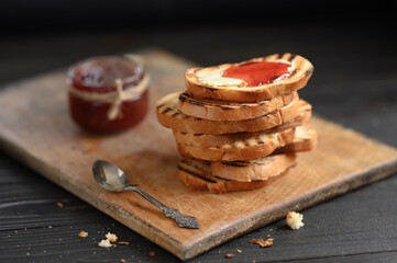 Toast bread with homemade strawberry jam and on rustic table with butter for breakfast or brunch.