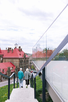 Women going down stairway and keeping hands in clasp 