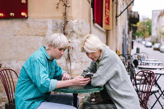 Lesbian couple picking and ordering dish for dinner in cafe 