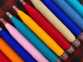 Colorful threads. Yarn. Bobbins with yarn. Fabric. Sewing threads. Skein of thread. Texture of colorful thread in spoolls.