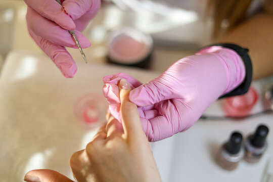 Manicurist inlays her client's nails with elegant, shiny rhinestons