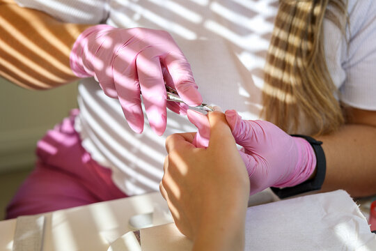A manicurist cuts a woman's cuticles in a beauty salon