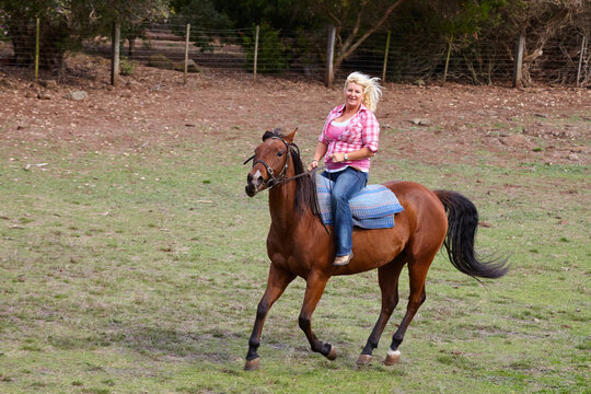Woman gallops on horse bareback