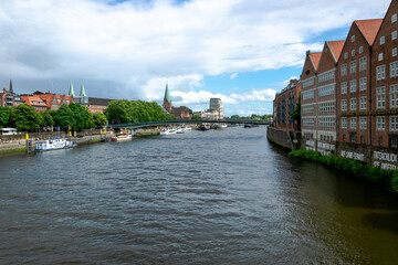 View of the city. Townhouses by the water along the shore. Barges on the river. Bremen, Germany.