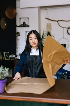 Serious employee preparing table for working process in shop 