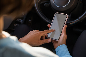 Female driver using touch screen smartphone and gps navigation in a car