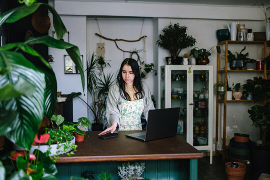 Saleswoman bringing cell phone to communicating with customer 