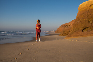 Young woman jogging and training on the beach in morning