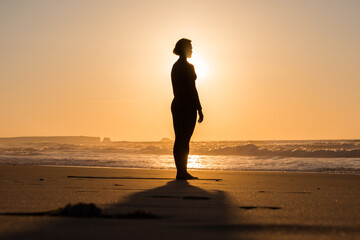 Beautiful girl is meditating the beach near the sea