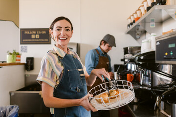 Happy cafe employee with homemade pastries