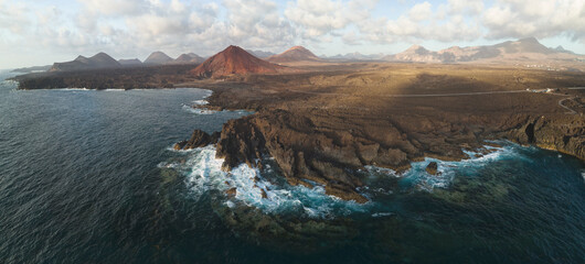 Fototapeta na wymiar red mountain near the sea over volcanic terrain