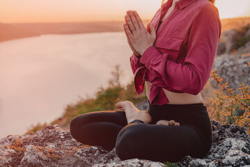 Woman practicing yoga, namaste gratitude mudra alone on high mountain