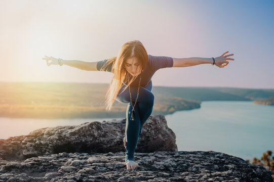 Woman practicing in Garudasana - eagle pose, yoga on high mountain