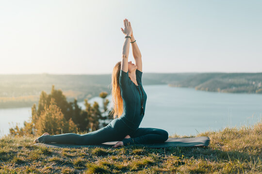 Woman In Blue Sports Wear Practicing Yoga On Sky Background