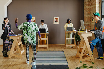 Man Greeting Colleagues At Work