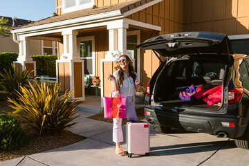 Excited woman in front home with suitcases smiling neighbors