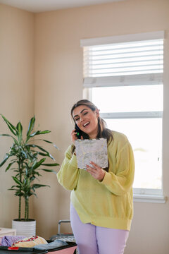 Woman with route map preparing suitcase at bedroom