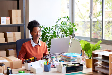 Woman working on laptop in office of delivery service