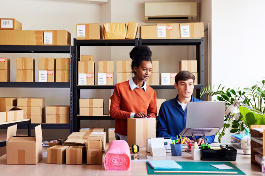 Diverse coworkers preparing to send parcels