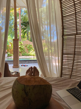UGC travel, home office, Female feet, coconut and laptop in Bali