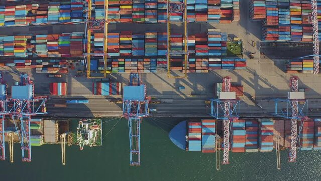 Loading and unloading a container ship in the port at the pier. Aerial view of business logistics import and export cargo transportation by container ship. Containers on a cargo vessel