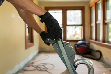 Man's hands on sander machine