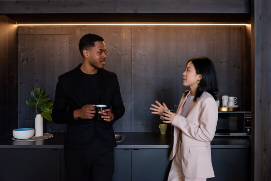 Diverse coworkers talking during break in office