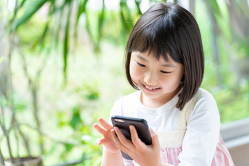 公園でスマートフォンを使う女の子