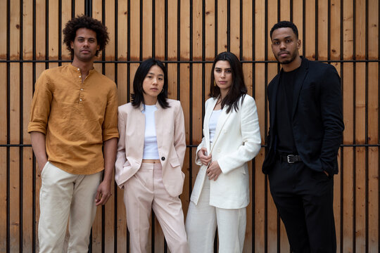 Confident business team against wooden wall