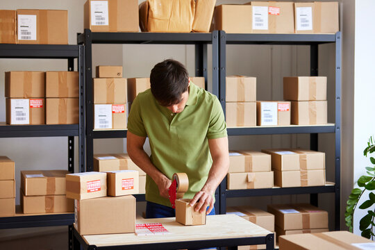 Logistic manager sealing parcel during work