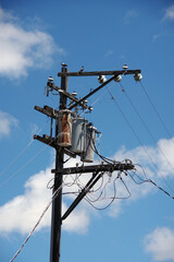 Electricity distribution pylon with power lines under blue sky