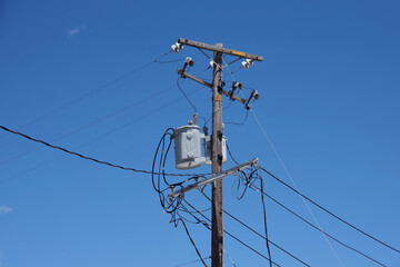 Electricity distribution pylon with power lines under blue sky