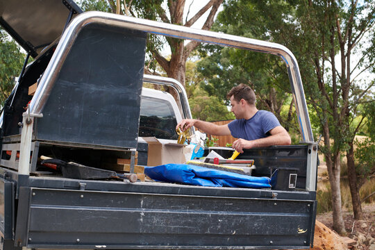 Workman packing tools into his work truck