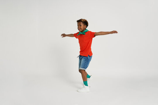 Cheerful boy spinning in studio