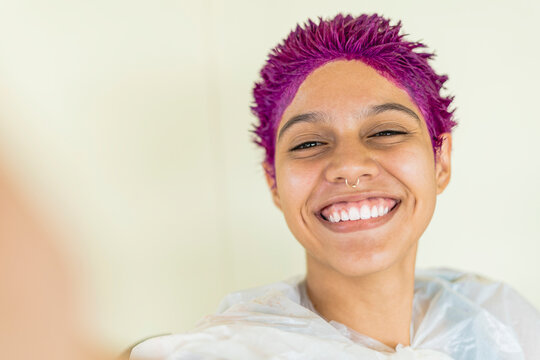 Selfie of a woman dying her hair purple