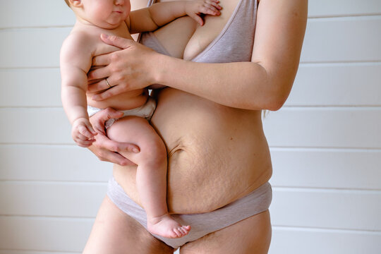 anonymous woman in lingerie holding baby