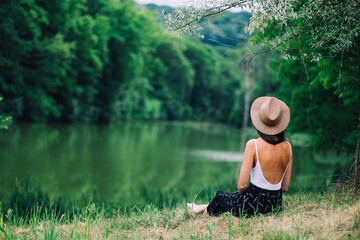 Woman relaxing on the shore of a summer lake
