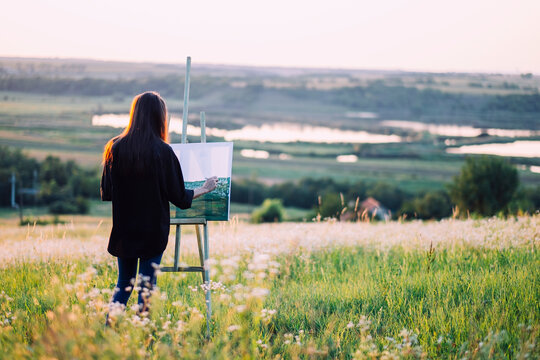 landscape painter woman at summer sunset