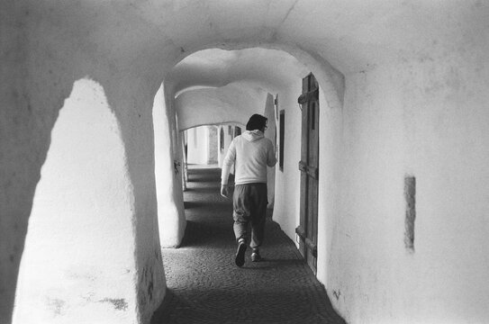 Anonymous man walking in ancient town in italy