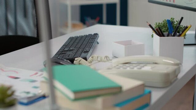 Empty company desk with landline phone and documents to work on financial strategy with business charts for startup growth. Nobody at table with professional computer. Close up.