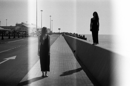 Two woman silhouette walking by the sea