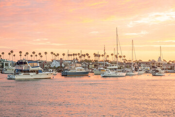 Yachts on the dock in the port against the backdrop of sunset on the ocean. California. Newport Beach
