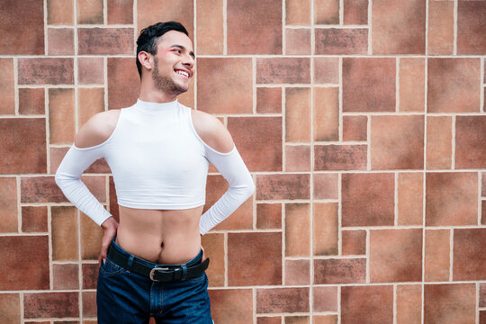 Young gay man in makeup posing sexily with a big smile
