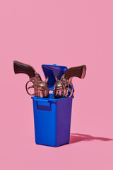 toy guns in a waste container